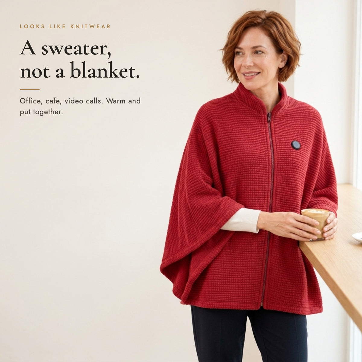 A sweater, not a blanket: Maple Red heated poncho worn in a cafe